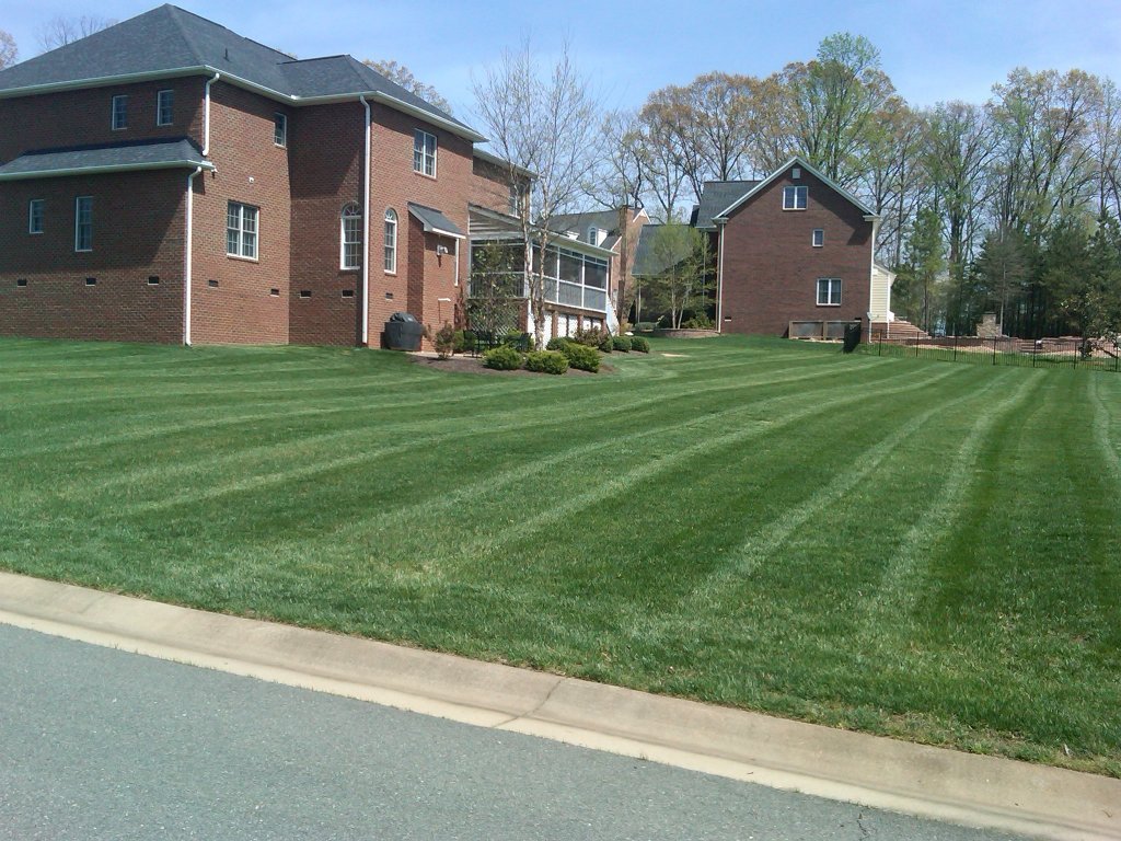 Lawn maintenance | brick house with mowed lawn
